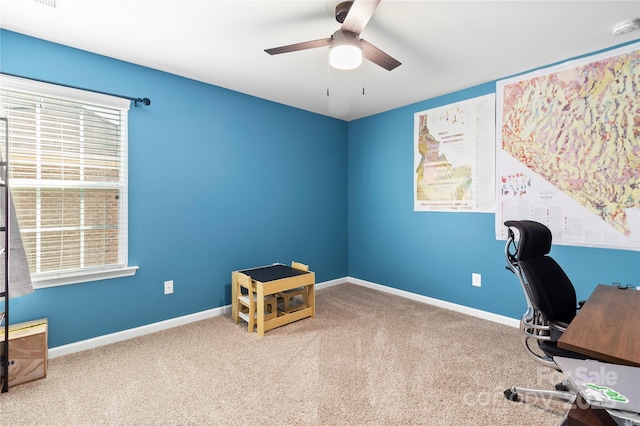 unfurnished office featuring baseboards, carpet, and a ceiling fan