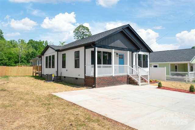 640 Central Dr NW, Concord, NC 28027 - view of front of house featuring fence, board and batten siding, crawl space, central air condition unit, and covered porch