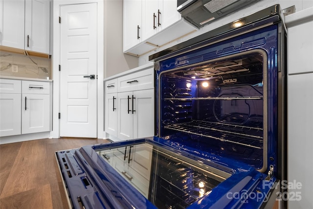 640 Central Dr NW, Concord, NC 28027 - details featuring beverage cooler, dark wood-style floors, light countertops, white cabinets, and tasteful backsplash