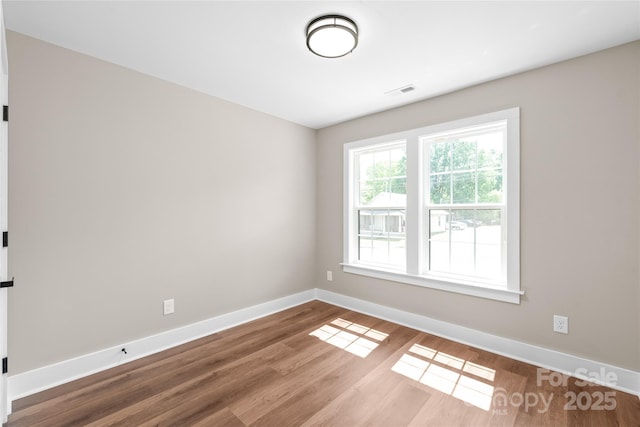 640 Central Dr NW, Concord, NC 28027 - empty room with baseboards, wood finished floors, and visible vents