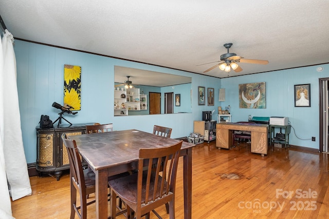 dining space with a ceiling fan, a textured ceiling, and light wood-style flooring