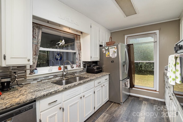 kitchen featuring dark wood finished floors, stainless steel appliances, a sink, and white cabinets