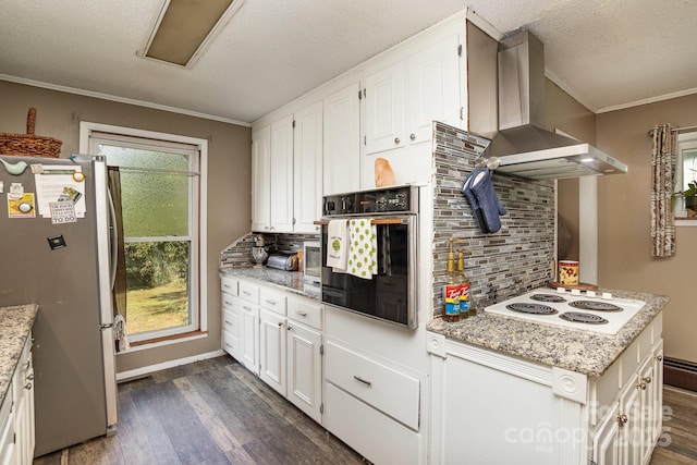 kitchen featuring white electric cooktop, dark wood-style floors, wall chimney range hood, freestanding refrigerator, and black oven