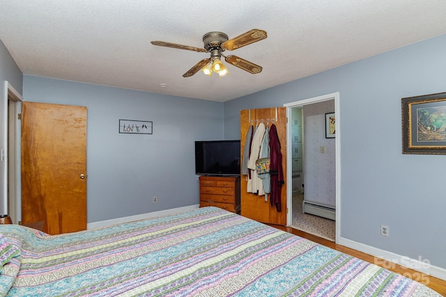bedroom featuring a baseboard heating unit, wood finished floors, baseboards, and a ceiling fan