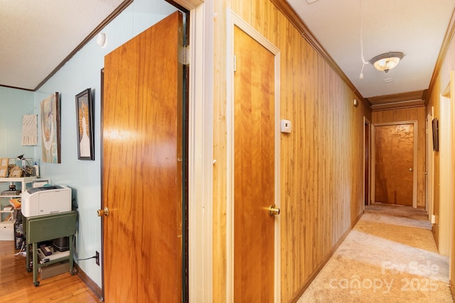 hall with light wood-type flooring and crown molding