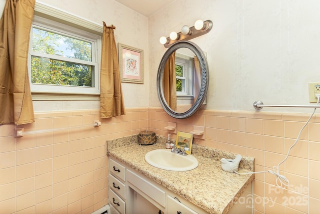 bathroom with wainscoting, tile walls, and vanity