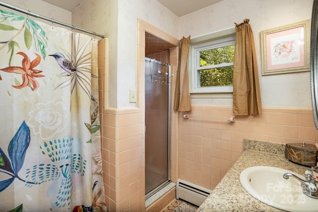 full bath with a baseboard heating unit, wainscoting, a stall shower, and tile walls