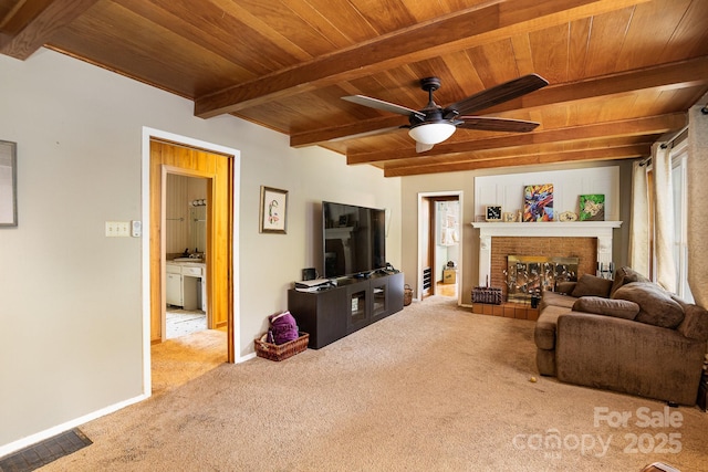 carpeted living area featuring baseboards, beamed ceiling, ceiling fan, wooden ceiling, and a fireplace