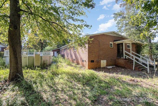 view of home's exterior featuring brick siding and crawl space