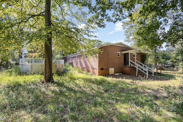 view of side of home with brick siding and crawl space