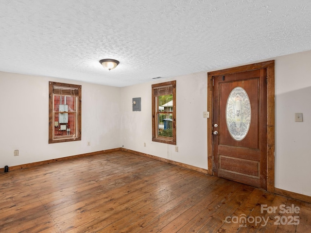 foyer entrance with baseboards, electric panel, hardwood / wood-style flooring, and a textured ceiling