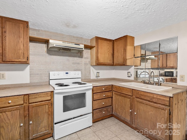 kitchen with brown cabinets, a sink, light countertops, white electric range oven, and under cabinet range hood