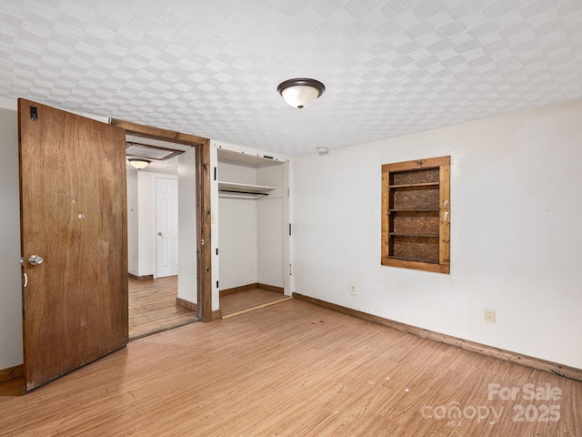 unfurnished bedroom featuring a closet, baseboards, and light wood-style floors