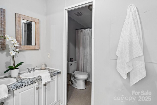 full bath with double vanity, a sink, visible vents, and toilet