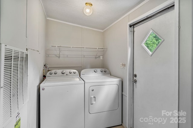 clothes washing area featuring a heating unit, laundry area, washing machine and dryer, and ornamental molding