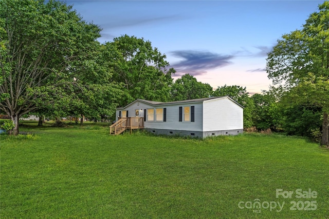 view of side of home featuring a lawn and crawl space