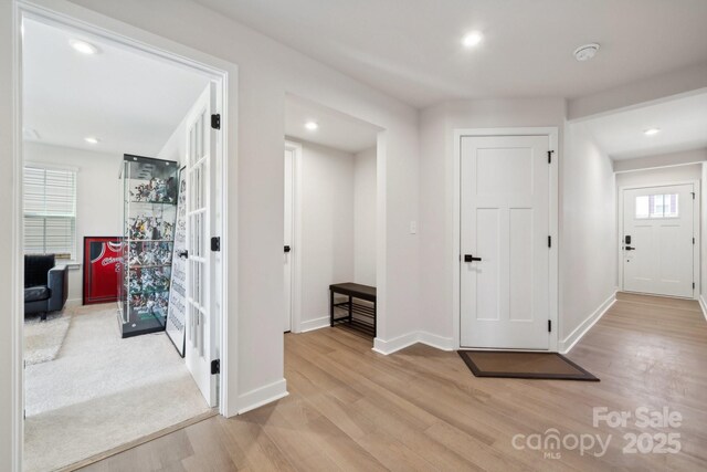 hallway with baseboards, recessed lighting, and wood finished floors