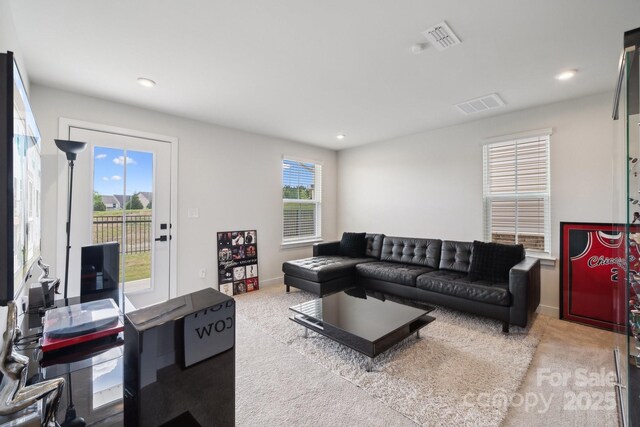 living area featuring carpet flooring, recessed lighting, and visible vents