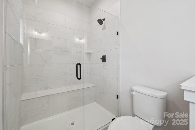 full bathroom featuring toilet and a shower stall