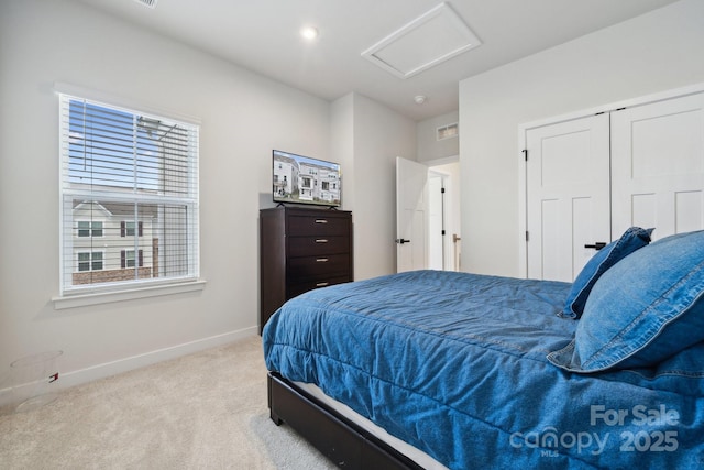 carpeted bedroom featuring attic access, a closet, and baseboards