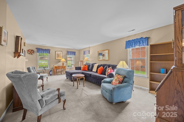 living area featuring baseboards, visible vents, a healthy amount of sunlight, and carpet floors