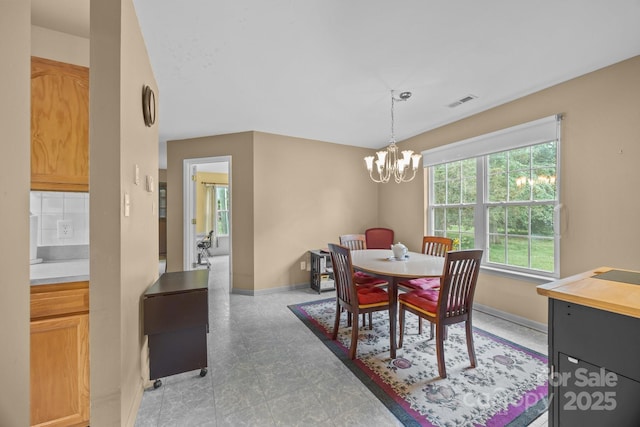 dining room featuring visible vents, a chandelier, and baseboards
