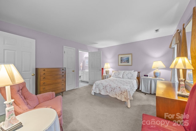 bedroom featuring visible vents, connected bathroom, and carpet flooring
