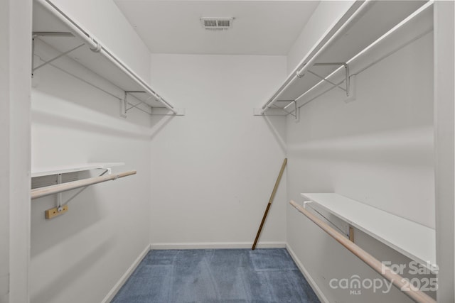 walk in closet with visible vents and dark carpet