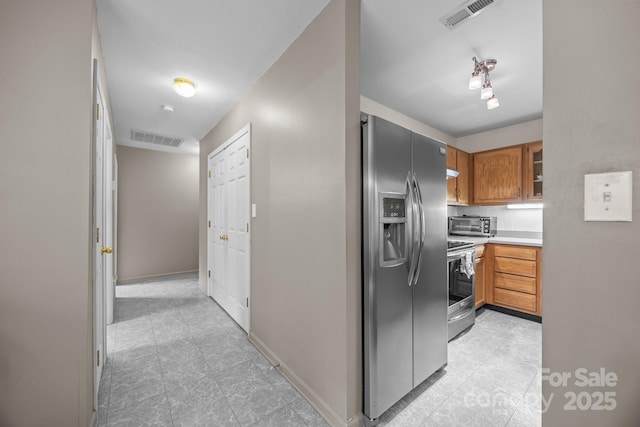 kitchen with appliances with stainless steel finishes, light tile patterned floors, visible vents, and light countertops