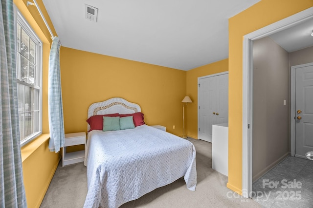 carpeted bedroom with visible vents and baseboards
