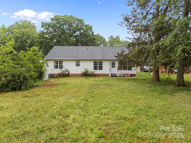 rear view of house with a lawn, crawl space, and roof with shingles