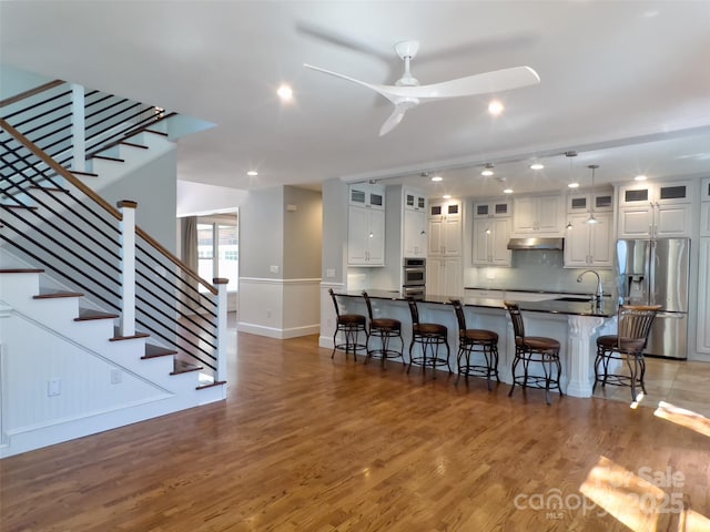 484 Chisholm Trl, Rutherfordton, NC 28139 - kitchen with appliances with stainless steel finishes, a breakfast bar area, baseboards, and under cabinet range hood