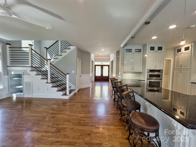 484 Chisholm Trl, Rutherfordton, NC 28139 - kitchen featuring glass insert cabinets, a kitchen breakfast bar, double oven, dark countertops, and wood finished floors