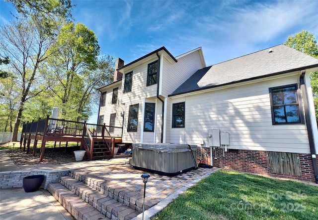 484 Chisholm Trl, Rutherfordton, NC 28139 - back of property with a chimney, a hot tub, a wooden deck, a patio area, and a lawn