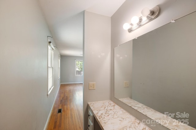 bathroom with visible vents, baseboards, and wood finished floors
