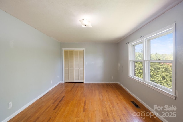 unfurnished room with visible vents, baseboards, and light wood-style floors