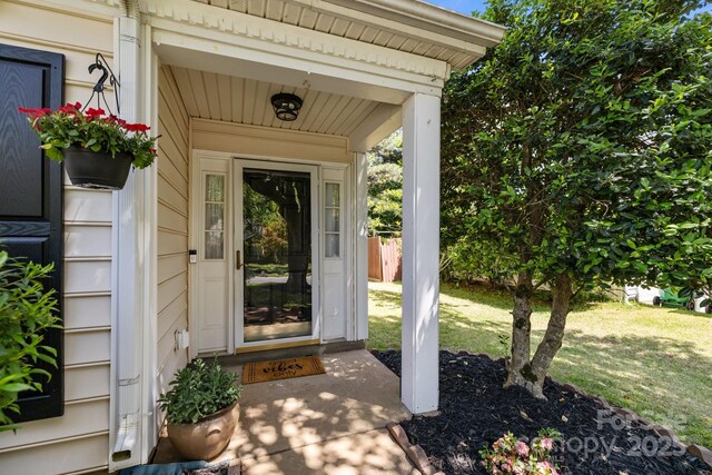doorway to property with a lawn
