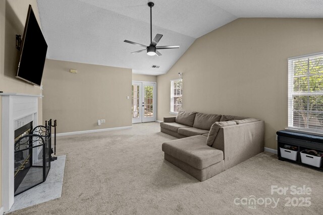 living area with carpet flooring, visible vents, french doors, a ceiling fan, and vaulted ceiling