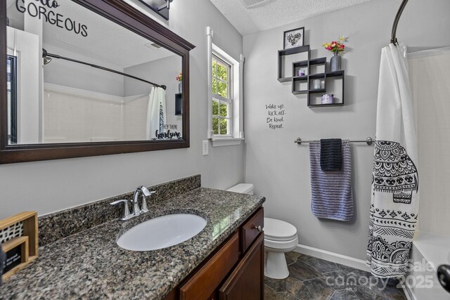 bathroom featuring a shower with curtain, baseboards, toilet, and a textured ceiling