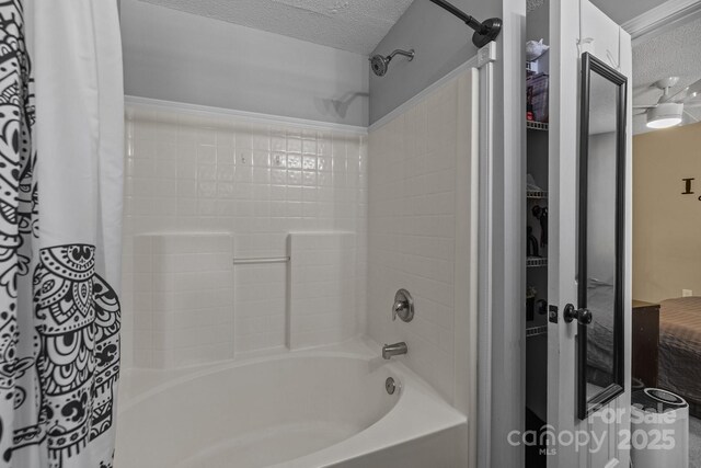 bathroom with a textured ceiling and shower / tub combo with curtain