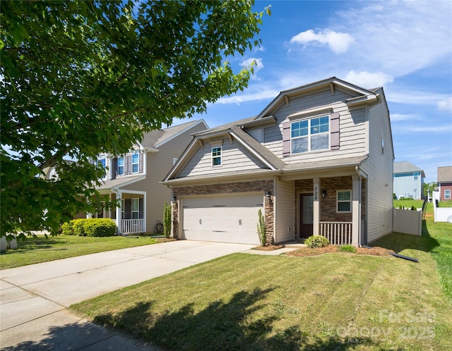 craftsman-style home with covered porch, an attached garage, concrete driveway, and a front lawn