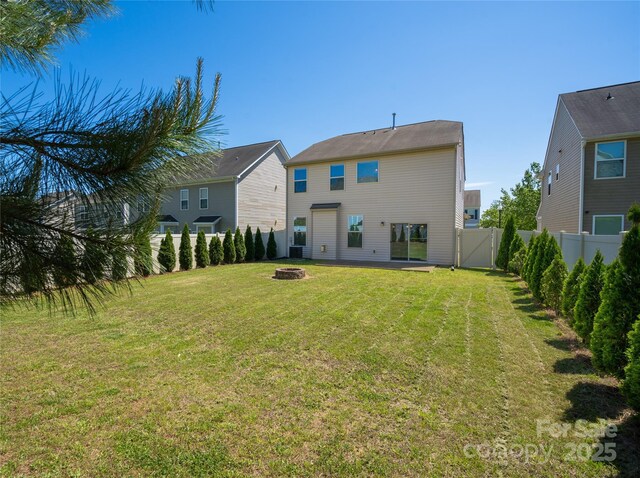 back of property featuring a lawn, a fire pit, and a fenced backyard
