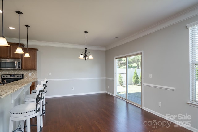 kitchen featuring backsplash, dark wood-style floors, a breakfast bar, and stainless steel appliances