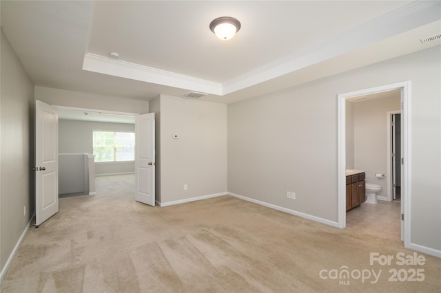 unfurnished bedroom with a tray ceiling, visible vents, light carpet, and baseboards