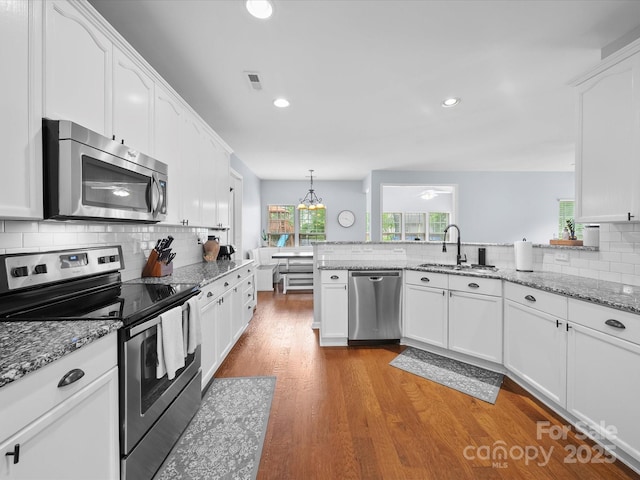 kitchen featuring stainless steel appliances, white cabinets, and a sink