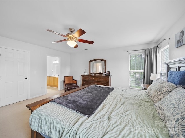 bedroom featuring ensuite bath, a ceiling fan, carpet flooring, and baseboards