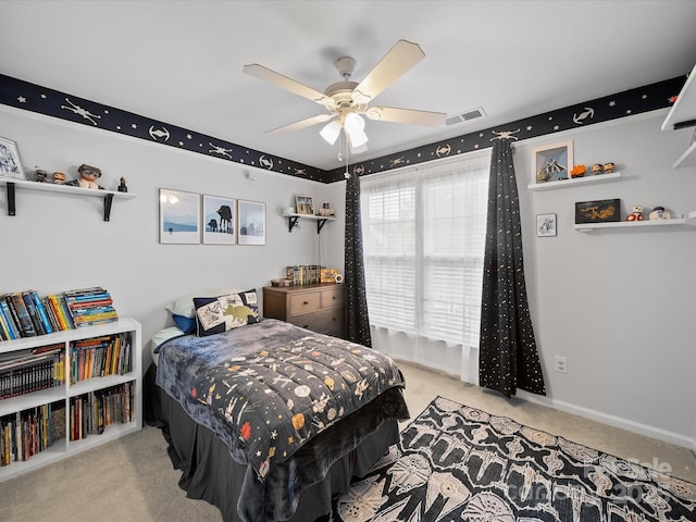 carpeted bedroom with visible vents, a ceiling fan, and baseboards