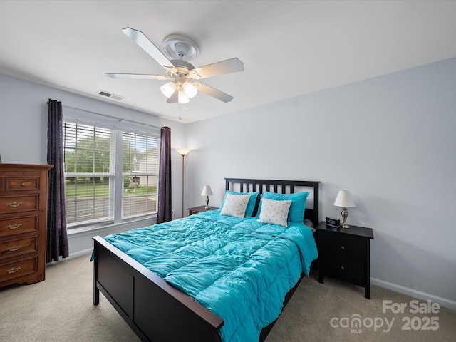 bedroom with light colored carpet, visible vents, ceiling fan, and baseboards