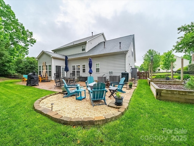 back of house featuring fence, a patio, a garden, a shingled roof, and a lawn