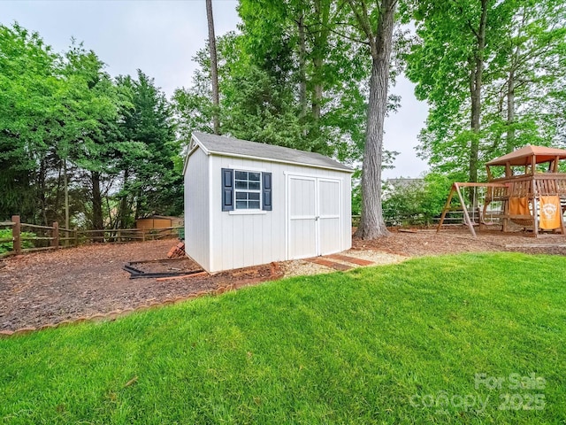 view of shed with a playground and fence
